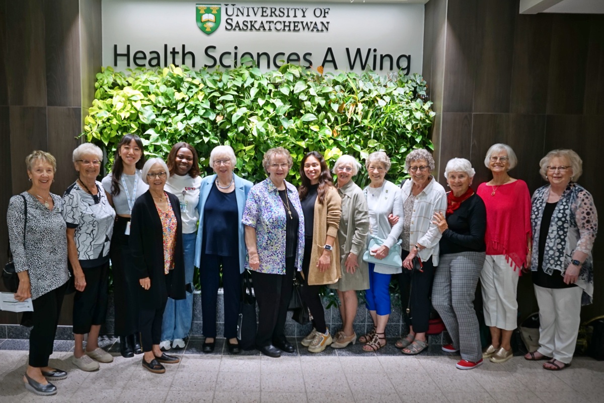group picture of alumni who attended the 1963 diploma class, 60th anniversary reunion, including three student volunteers, and 11 alumni