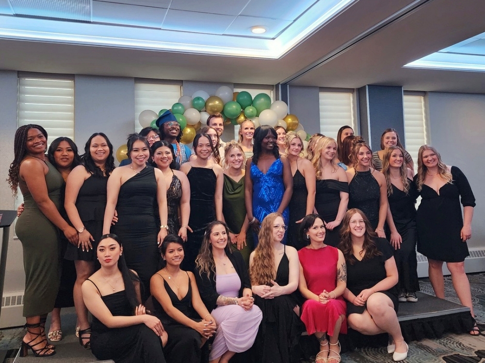 a group photo of the graduating students who attended the Regina grad banquet, all smiling for a photo in front of a balloon arch.