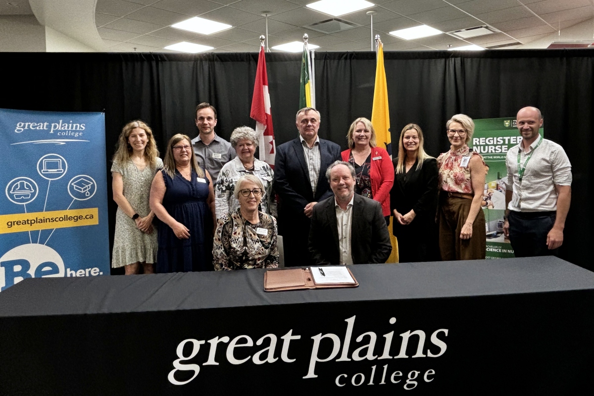 group photo of 11 people smiling in front of a black curtain 