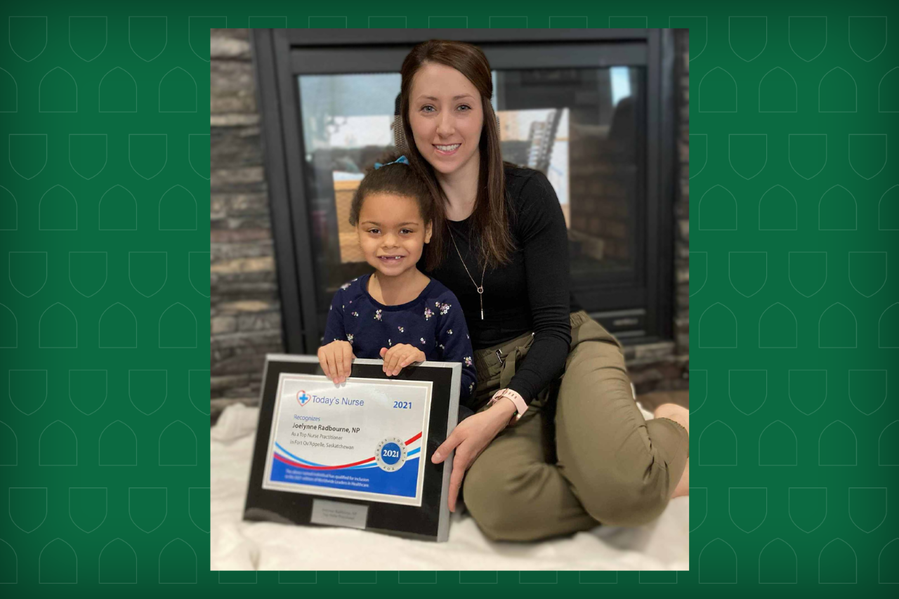 Joelynne Radbourne sitting with her daughter in front of a fireplace