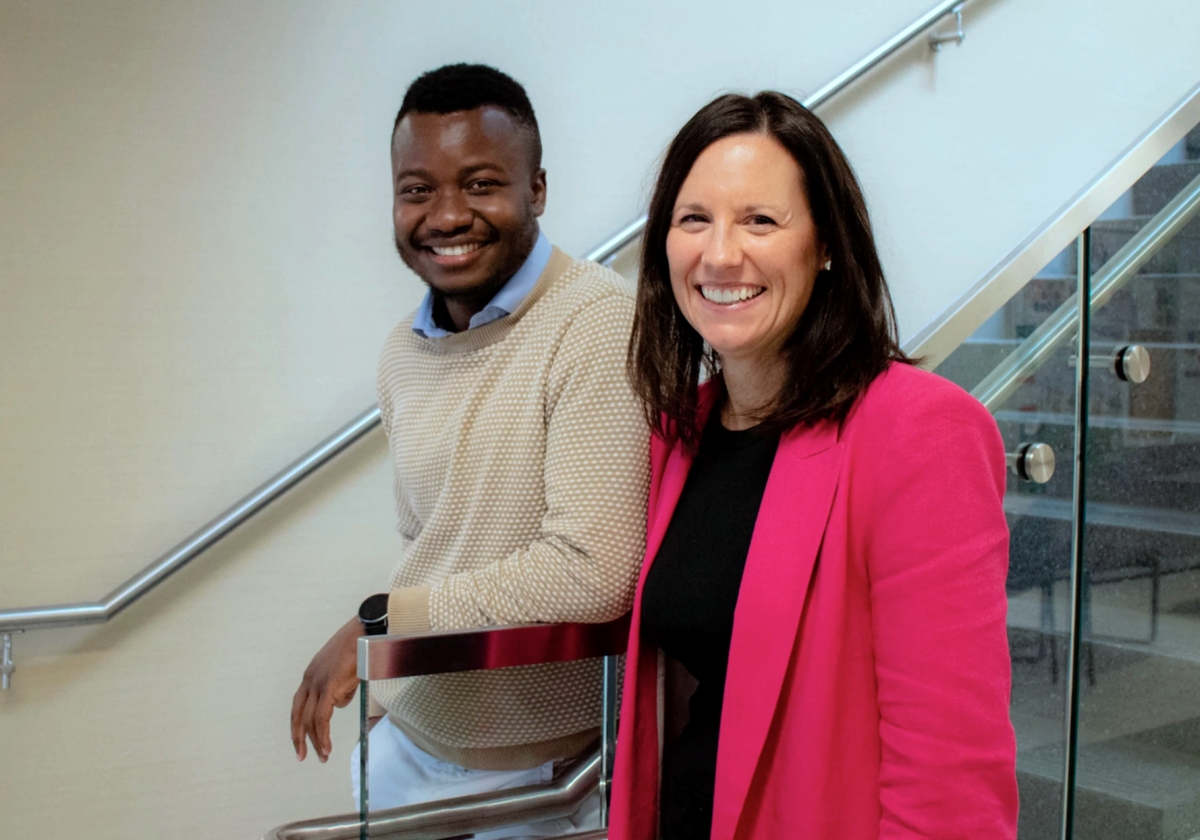 Drs. Jacob Alhassan and Charlene Thompson smiling for the camera next to a set of stairs at the University of Saskatchewan