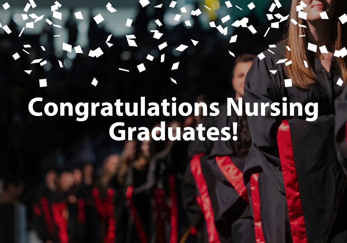Graduates in black and red regalia walk across a stage with white confetti and Congratulations Nursing Graduates wrote across image. 